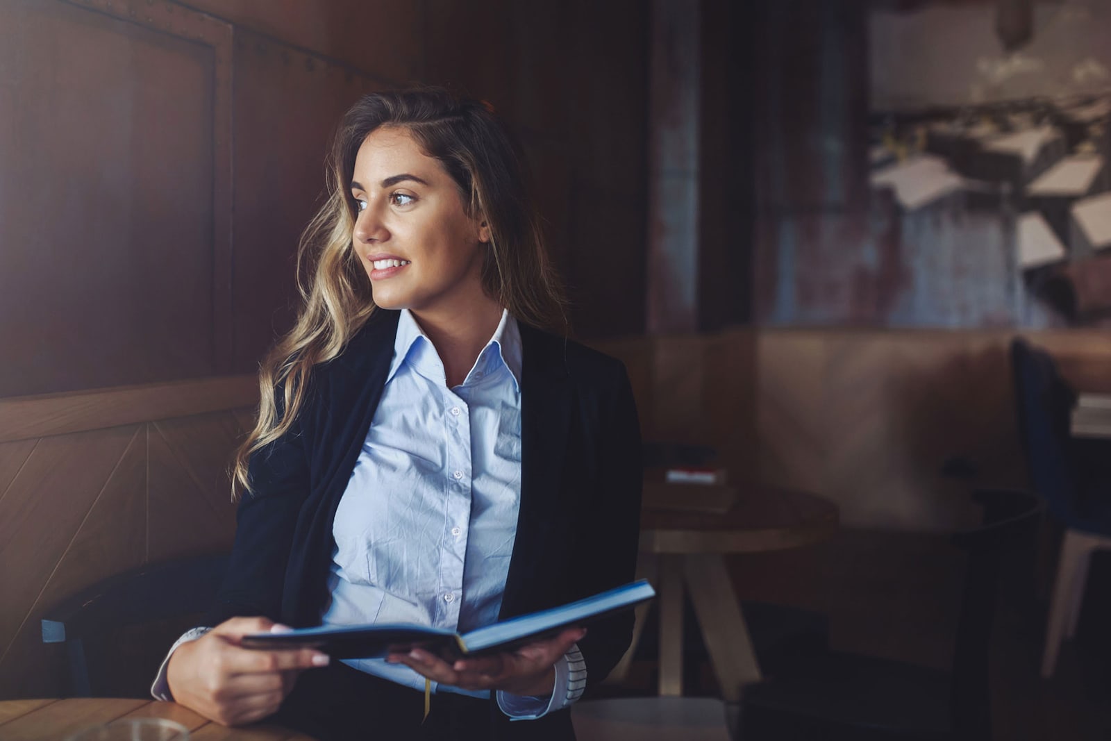 Home amb un bolígraf a la mà, assegut vora el seu ordinador i un quadern